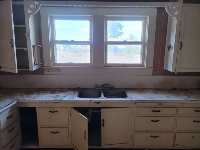 a kitchen with windows and cabinets