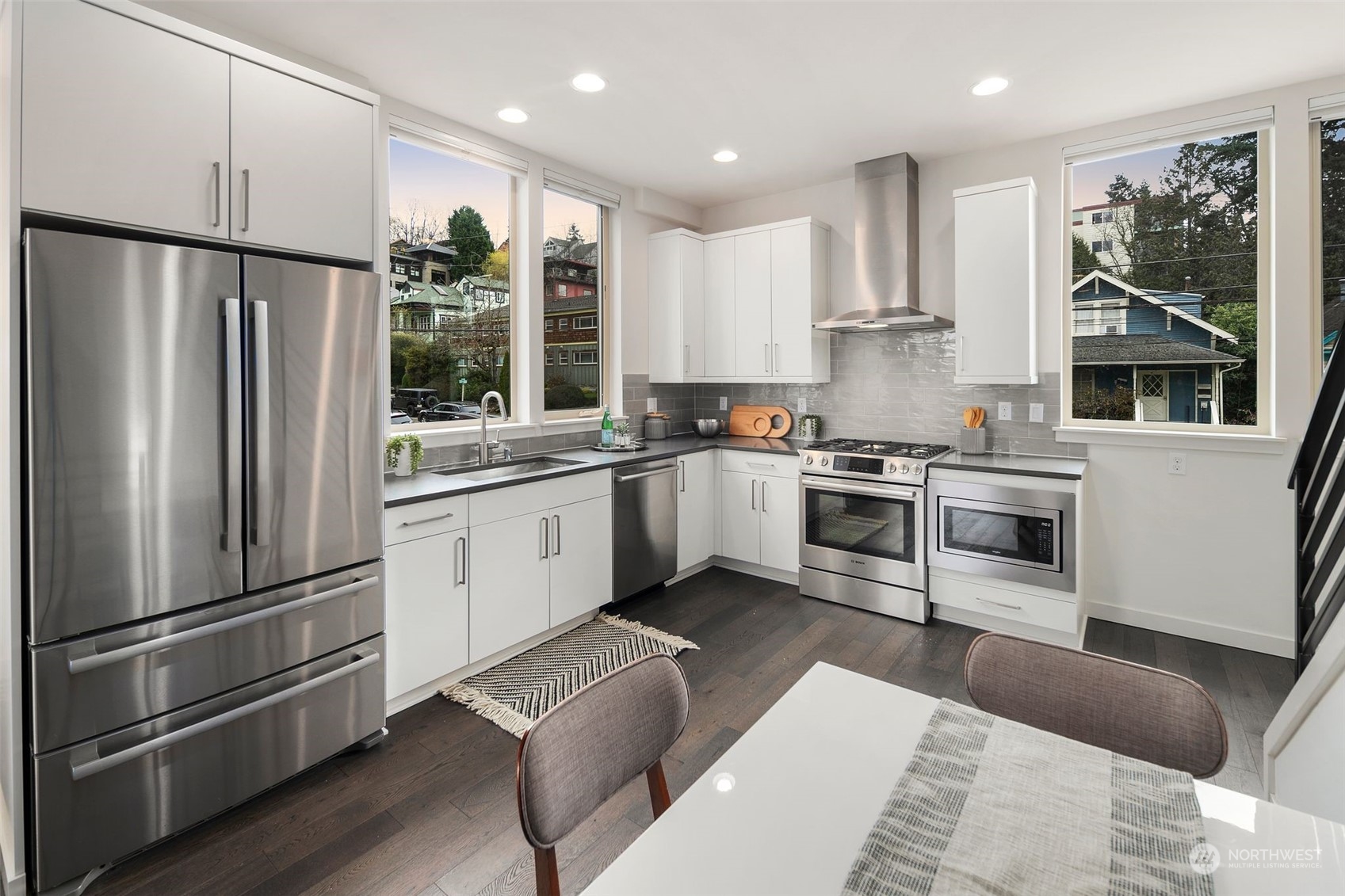 3625 Evanston Avenue North, Unit B Seattle, WA 98103 - Photo 13 of 37 a kitchen with stainless steel appliances granite countertop a refrigerator a sink dishwasher a stove and white cabinets with wooden floor