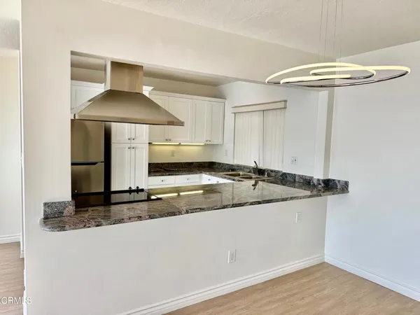 a kitchen with granite countertop white cabinets and sink