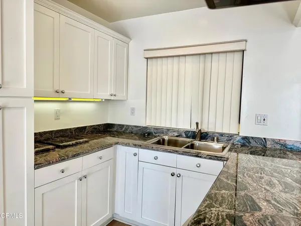 a kitchen with a refrigerator and a stove top oven