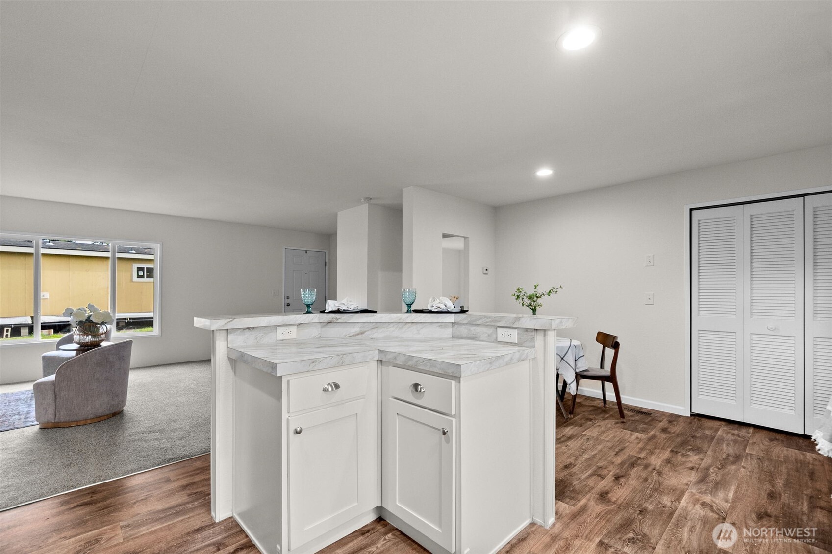 6748 Fir Tree Road Southeast, Unit 15 Olympia, WA 98513 - Photo 11 of 28 a view of a kitchen with kitchen island a stove a refrigerator a dining table and chairs with wooden floor