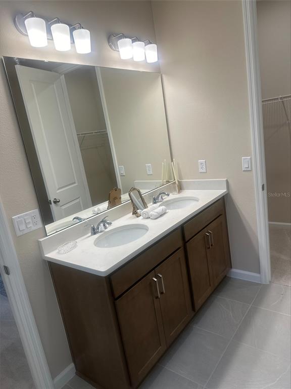 1026 Swamp Chestnut Loop Lady Lake, FL 32159 - Photo 9 of 19 a bathroom with a double vanity sink and a mirror