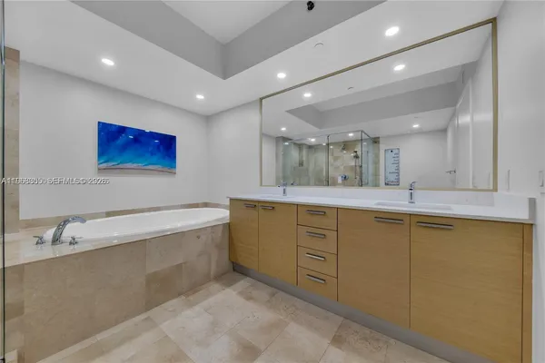 a bathroom with a tub sink and mirror