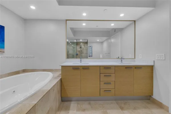 a bathroom with a tub sink and mirror