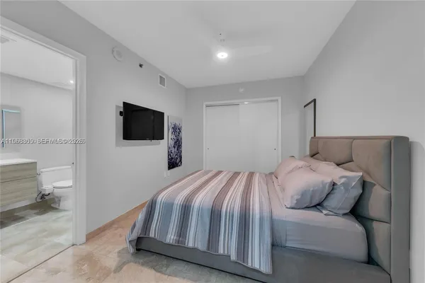 a bedroom with a bed and a flat screen tv