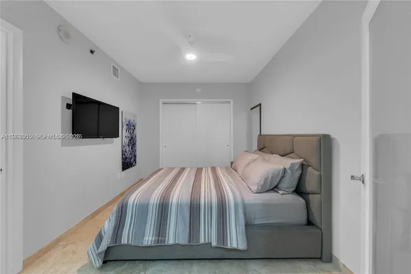 a bedroom with a bed and a flat screen tv