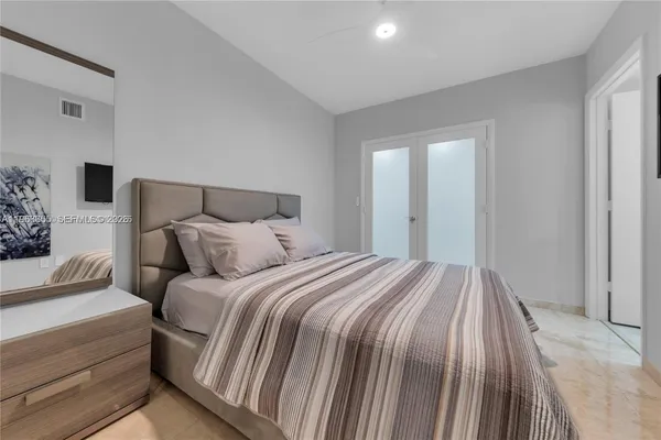 a bedroom with a bed and a mirror