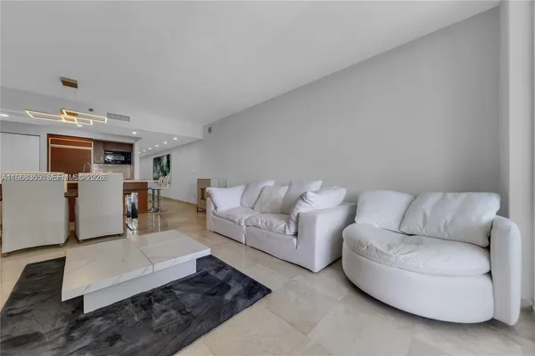 a living room with furniture and view of kitchen