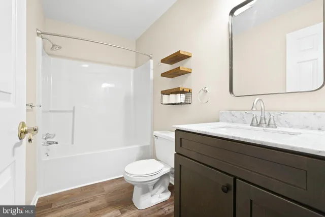 a bathroom with a granite countertop sink toilet a mirror and shower