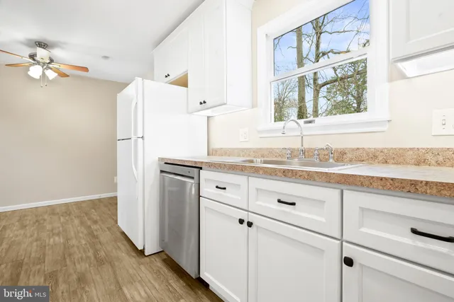 a kitchen with granite countertop white cabinets and white appliances