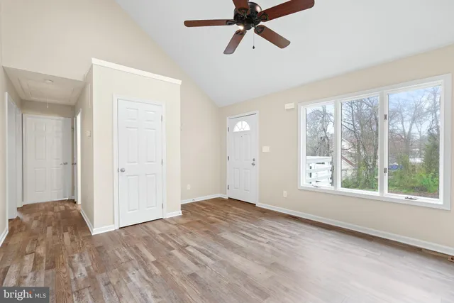 a view of a livingroom with a window and wooden floor