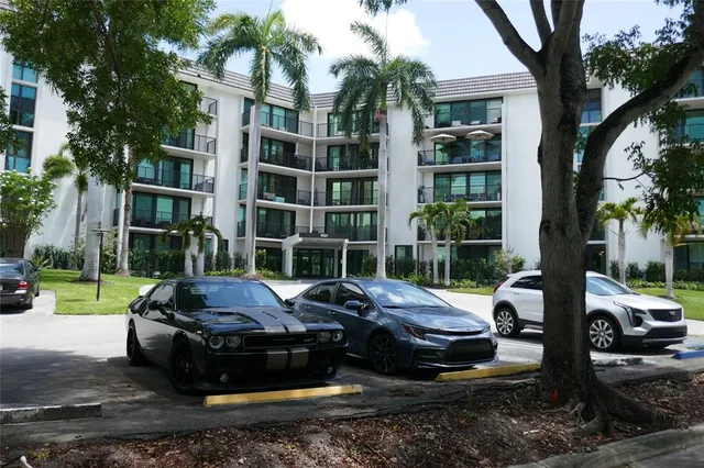 a view of a yard with a car parked in front of a house