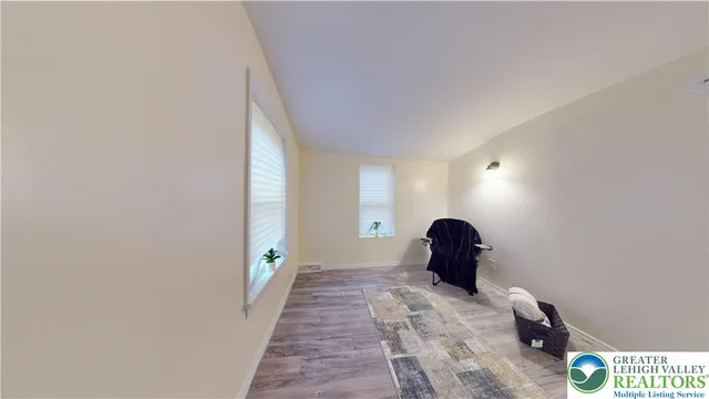a view of a bedroom with wooden floor and dresser