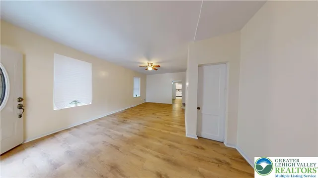 a view of an empty room with wooden floor