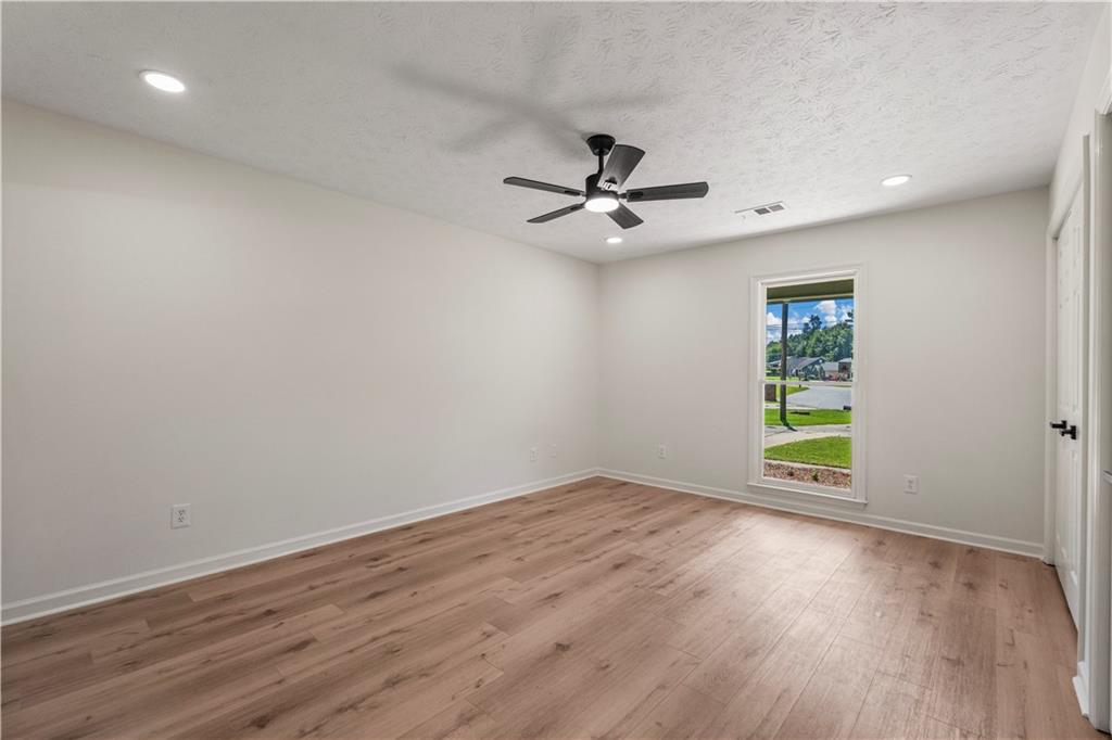 766 Lee Road Phenix City, AL 36870 - Photo 12 of 30 Empty room with light wood-type flooring, a ceiling fan, recessed lighting, and a textured ceiling
