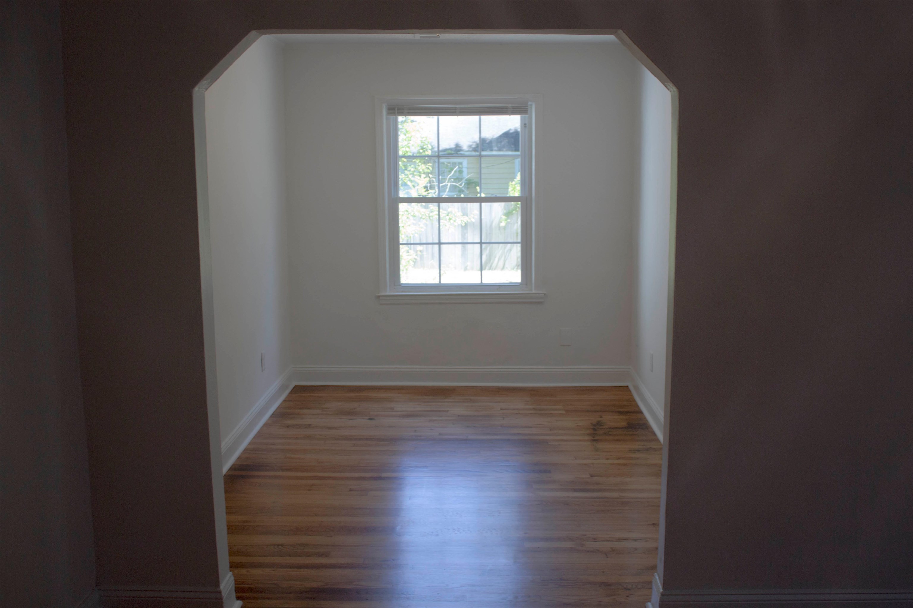 1058 Prescott Road Memphis, TN 38111 - Photo 4 of 16 a view of an empty room with wooden floor and a window