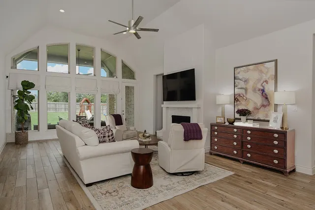 a living room with furniture a flat screen tv and a fireplace