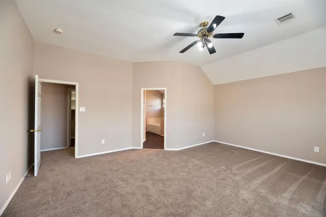 a view of an empty room with a ceiling fan