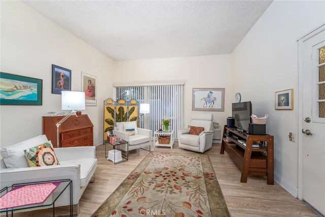 a kitchen with stainless steel appliances kitchen island granite countertop a refrigerator a stove a sink dishwasher and white cabinets with wooden floor