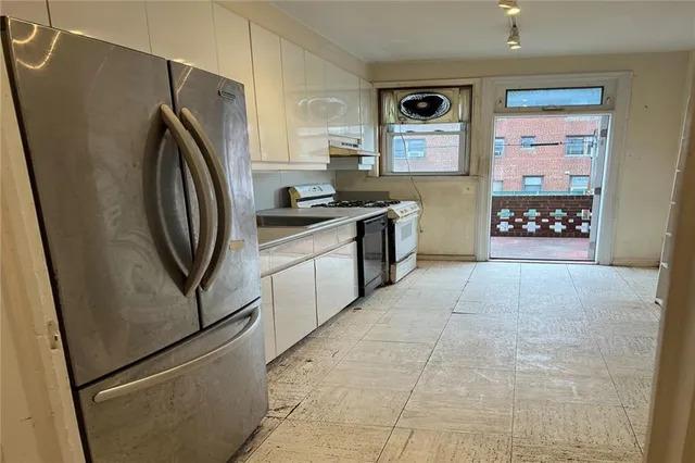 a kitchen with stainless steel appliances granite countertop a refrigerator and a stove
