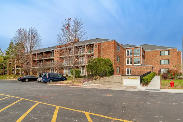 a front view of a building with cars parked