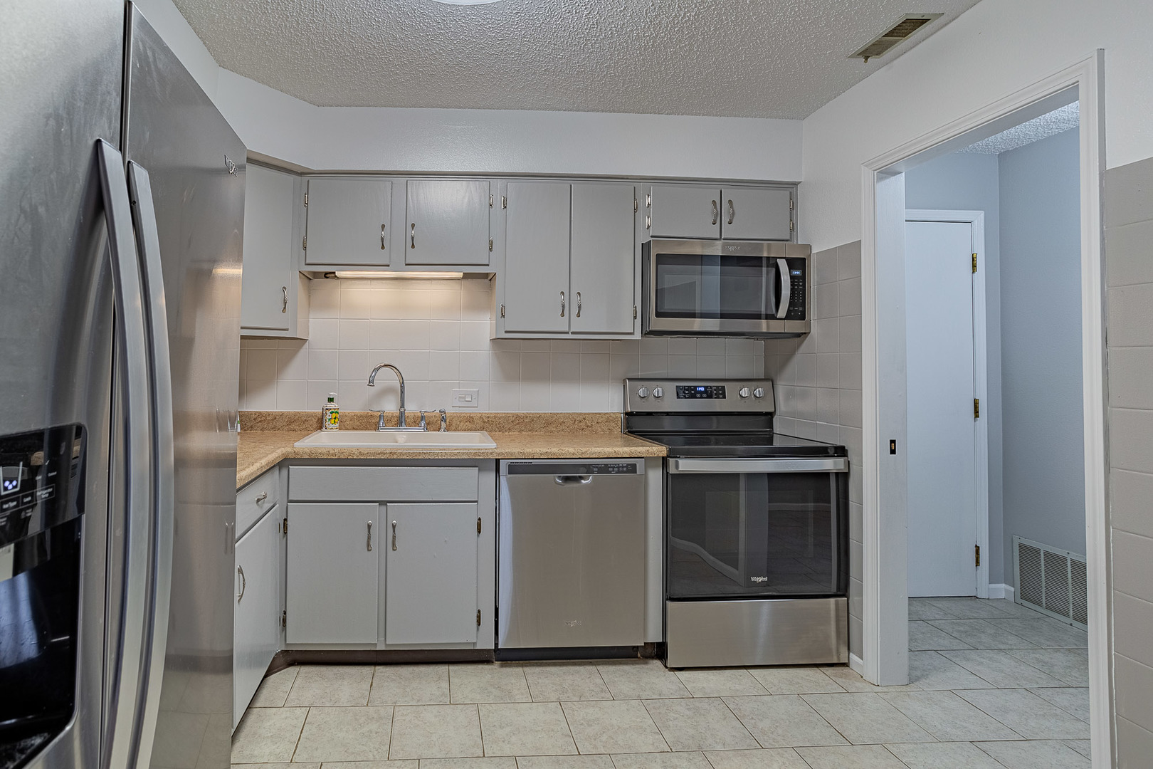 520 Biesterfield Road, Unit E220 Elk Grove Village, IL 60007 - Photo 4 of 21 a kitchen with stainless steel appliances granite countertop a refrigerator and a sink