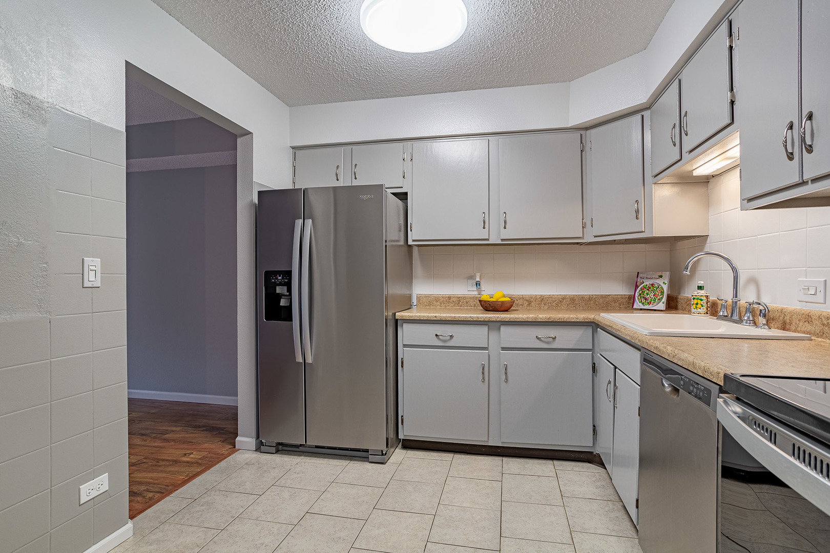 520 Biesterfield Road, Unit E220 Elk Grove Village, IL 60007 - Photo 5 of 21 a kitchen with stainless steel appliances granite countertop a refrigerator sink and cabinets