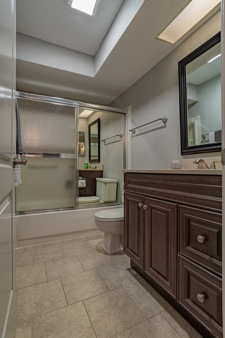 520 Biesterfield Road, Unit E220 Elk Grove Village, IL 60007 - Photo 8 of 21 a bathroom with a toilet a sink and mirror