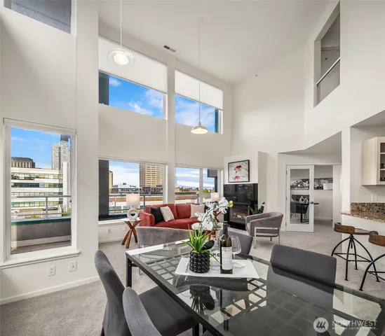a living room with furniture kitchen view and a large window