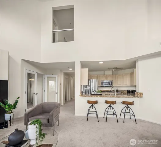 a room with stainless steel appliances kitchen island granite countertop furniture and a view of kitchen