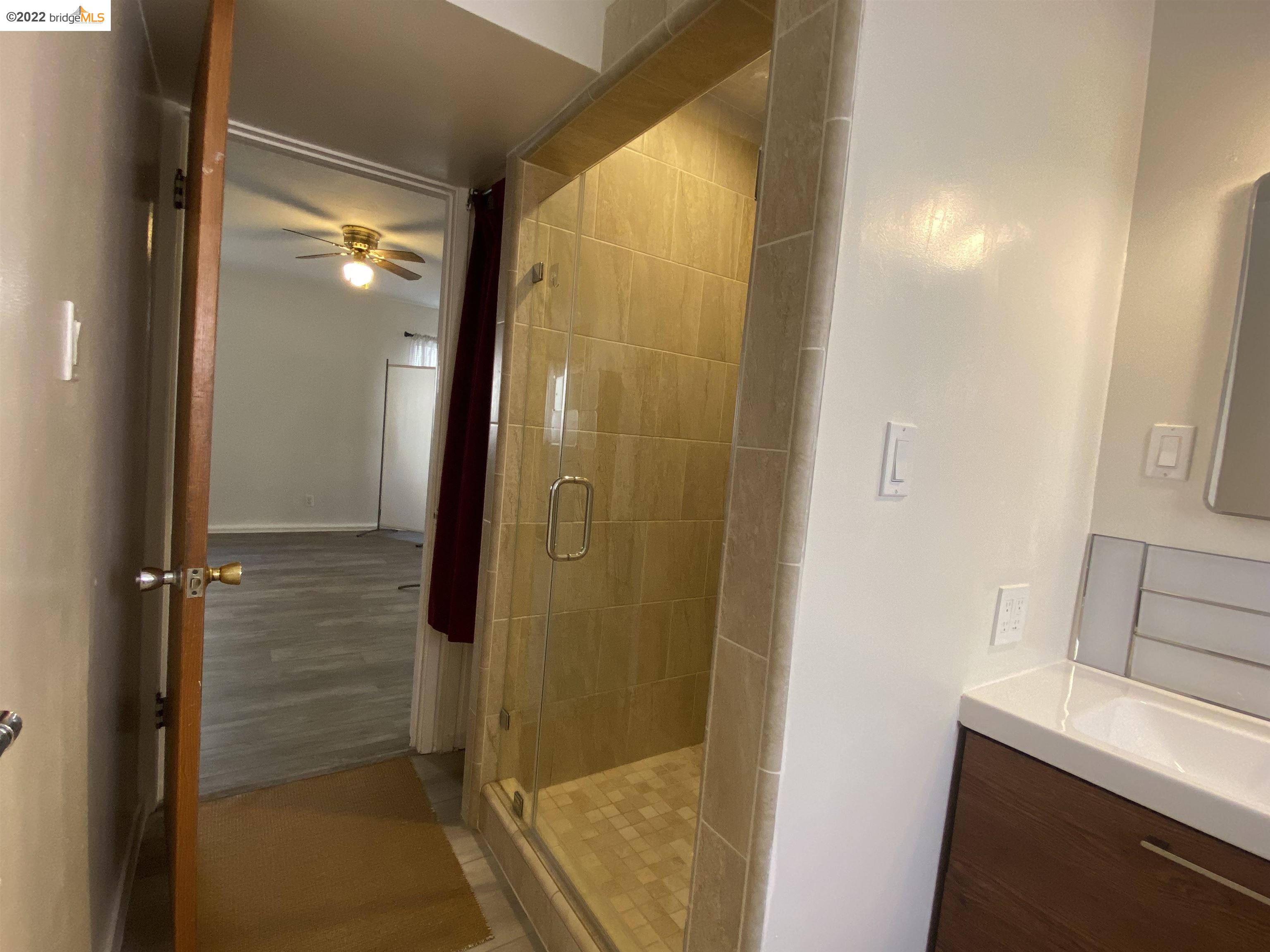 5357 Bryant Avenue Oakland, CA 94618 - Photo 18 of 26 a bathroom with a glass shower door
