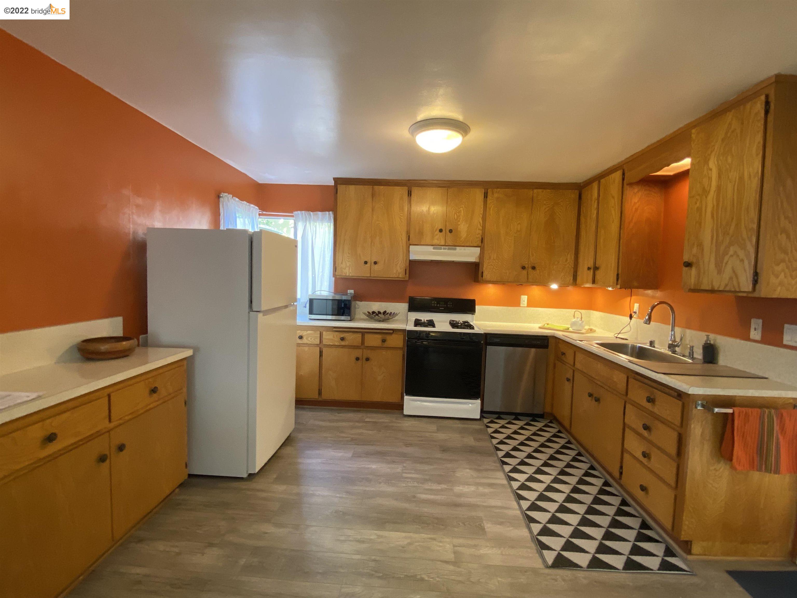 5357 Bryant Avenue Oakland, CA 94618 - Photo 6 of 26 a kitchen with stainless steel appliances a refrigerator sink and cabinets