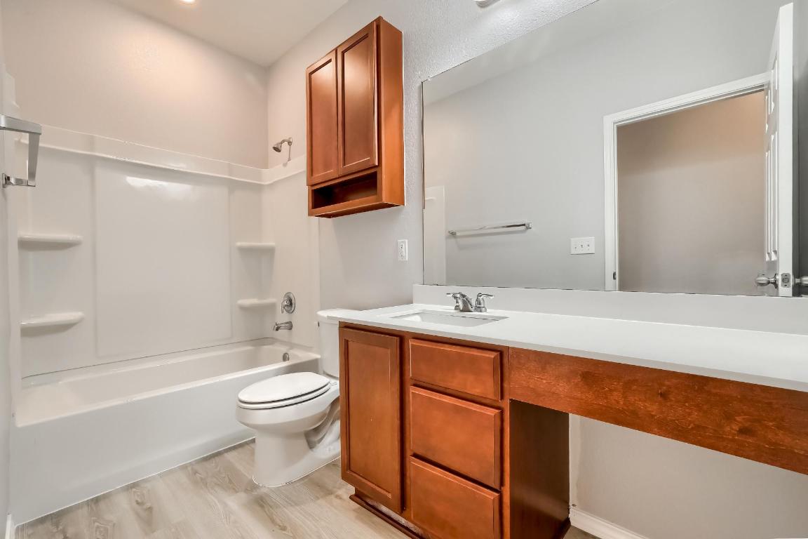7308 Altidore Drive Austin, TX 78744 - Photo 19 of 24 Full bathroom with vanity, tub / shower combination, and light wood finished floors
