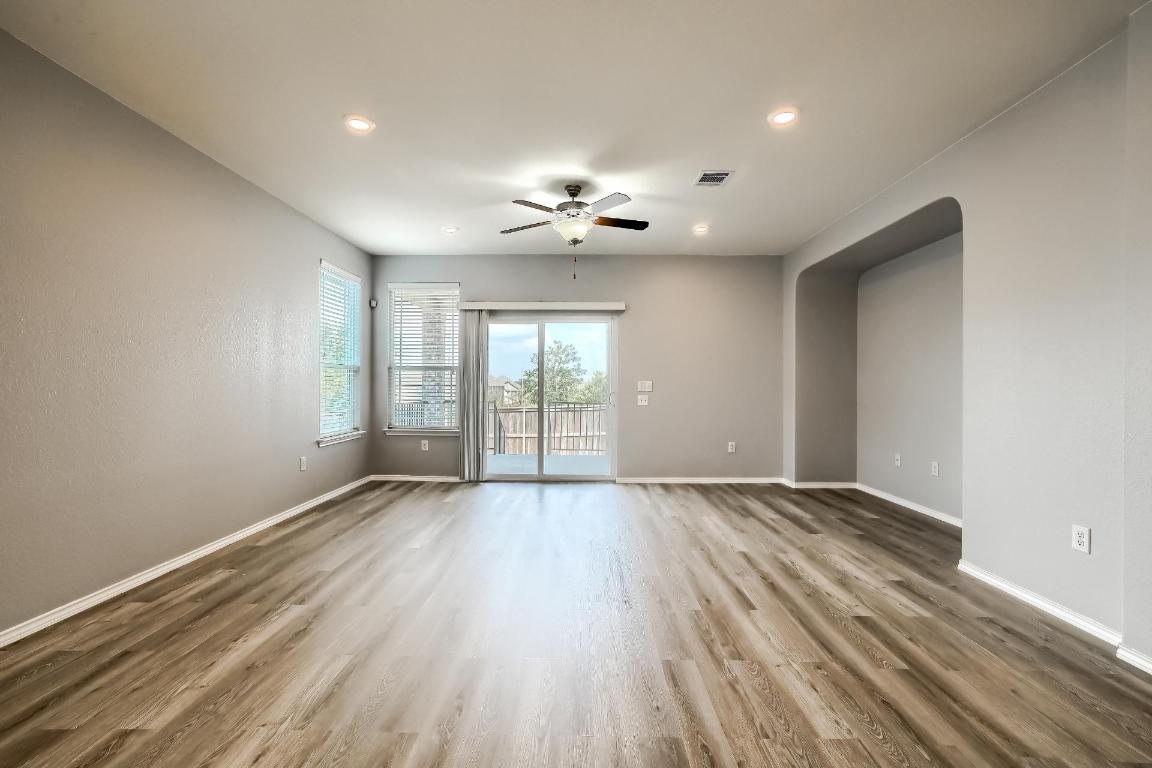 7308 Altidore Drive Austin, TX 78744 - Photo 2 of 24 Spare room with light wood-type flooring, recessed lighting, ceiling fan, and arched walkways