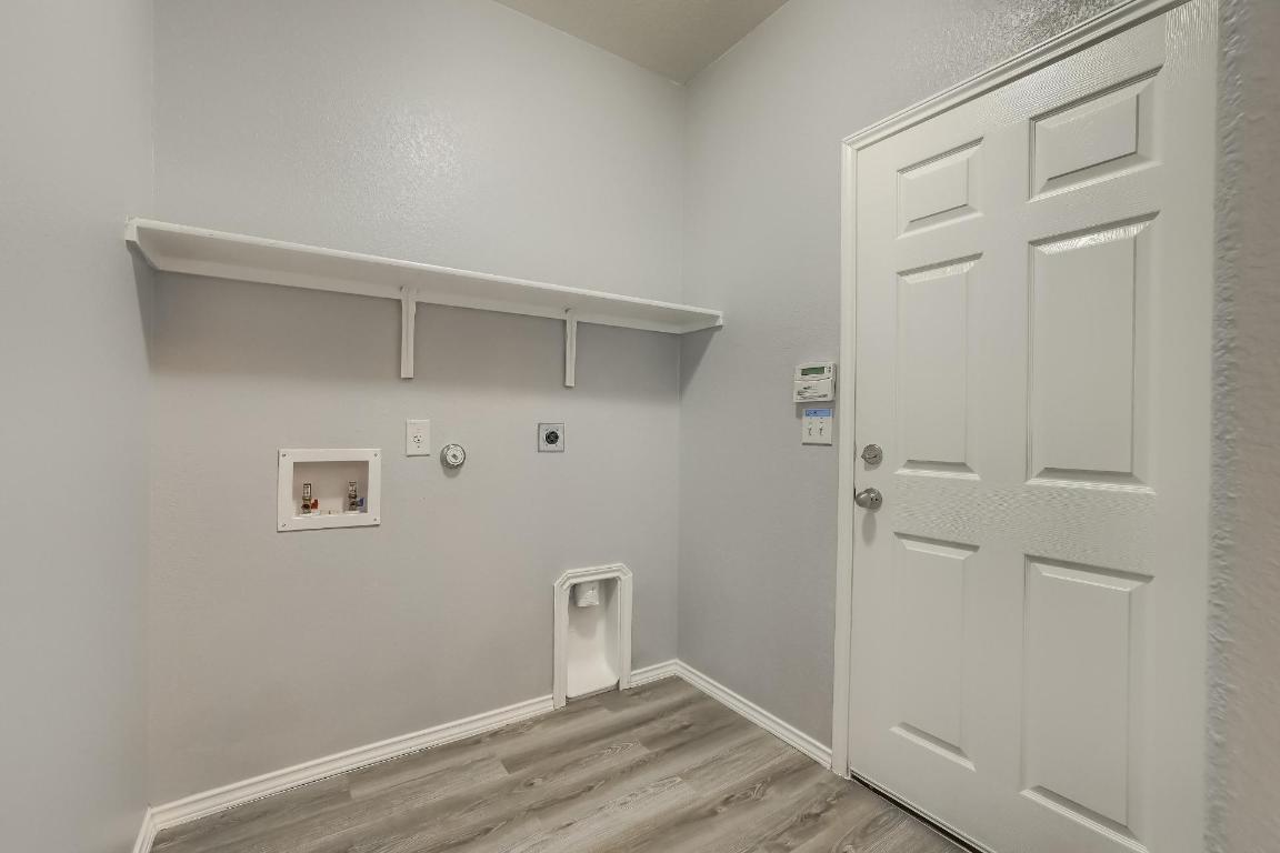 7308 Altidore Drive Austin, TX 78744 - Photo 22 of 24 Laundry room with gas dryer hookup, light wood-style floors, hookup for a washing machine, and hookup for an electric dryer