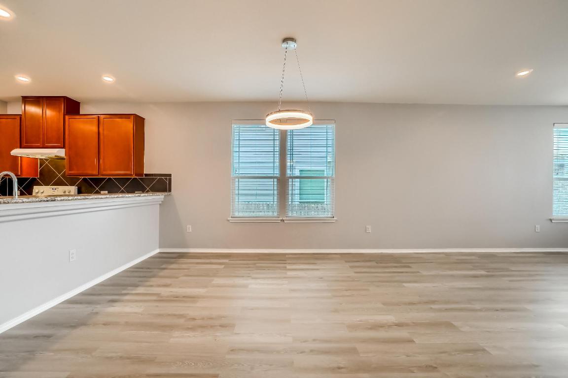 7308 Altidore Drive Austin, TX 78744 - Photo 8 of 24 Unfurnished dining area with recessed lighting, light wood-style flooring, and plenty of natural light