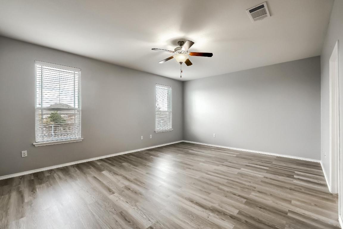7308 Altidore Drive Austin, TX 78744 - Photo 9 of 24 Empty room with light wood-type flooring and ceiling fan