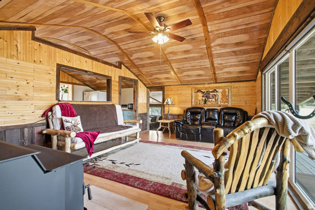 1663 Lancer Lane Evanston, UT 82930 - Photo 16 of 101 Vaulted wood-paneled ceiling with ceiling fan, wood-paneled walls, and sliding glass door