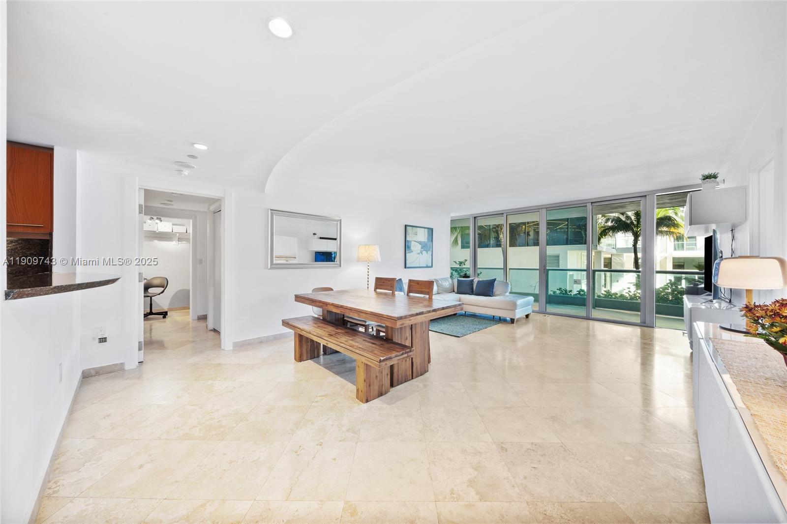 9401 Collins Avenue, Unit 205 Surfside, FL 33154 - Photo 13 of 36 a living room with furniture large white walls and flat screen tv
