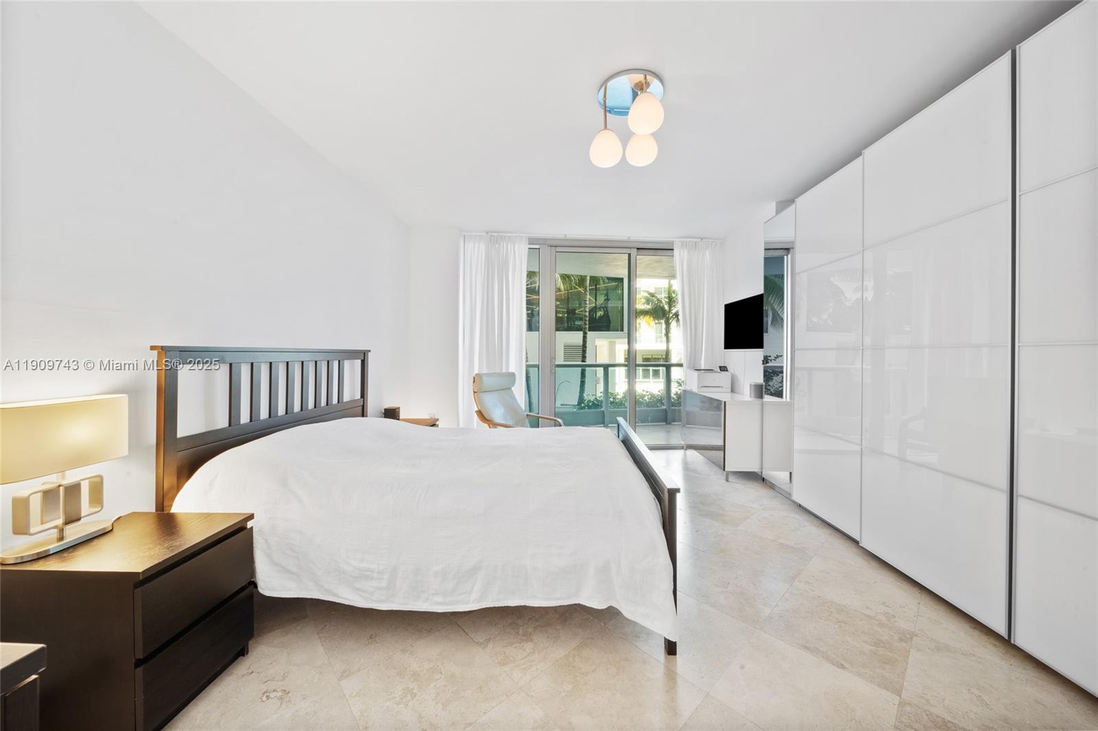 9401 Collins Avenue, Unit 205 Surfside, FL 33154 - Photo 20 of 36 a bed room with a bed and a chair