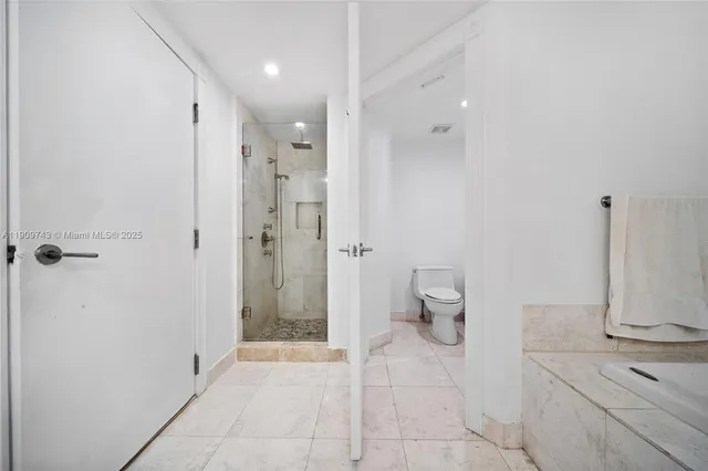 a bathroom with a granite countertop sink a toilet and a mirror
