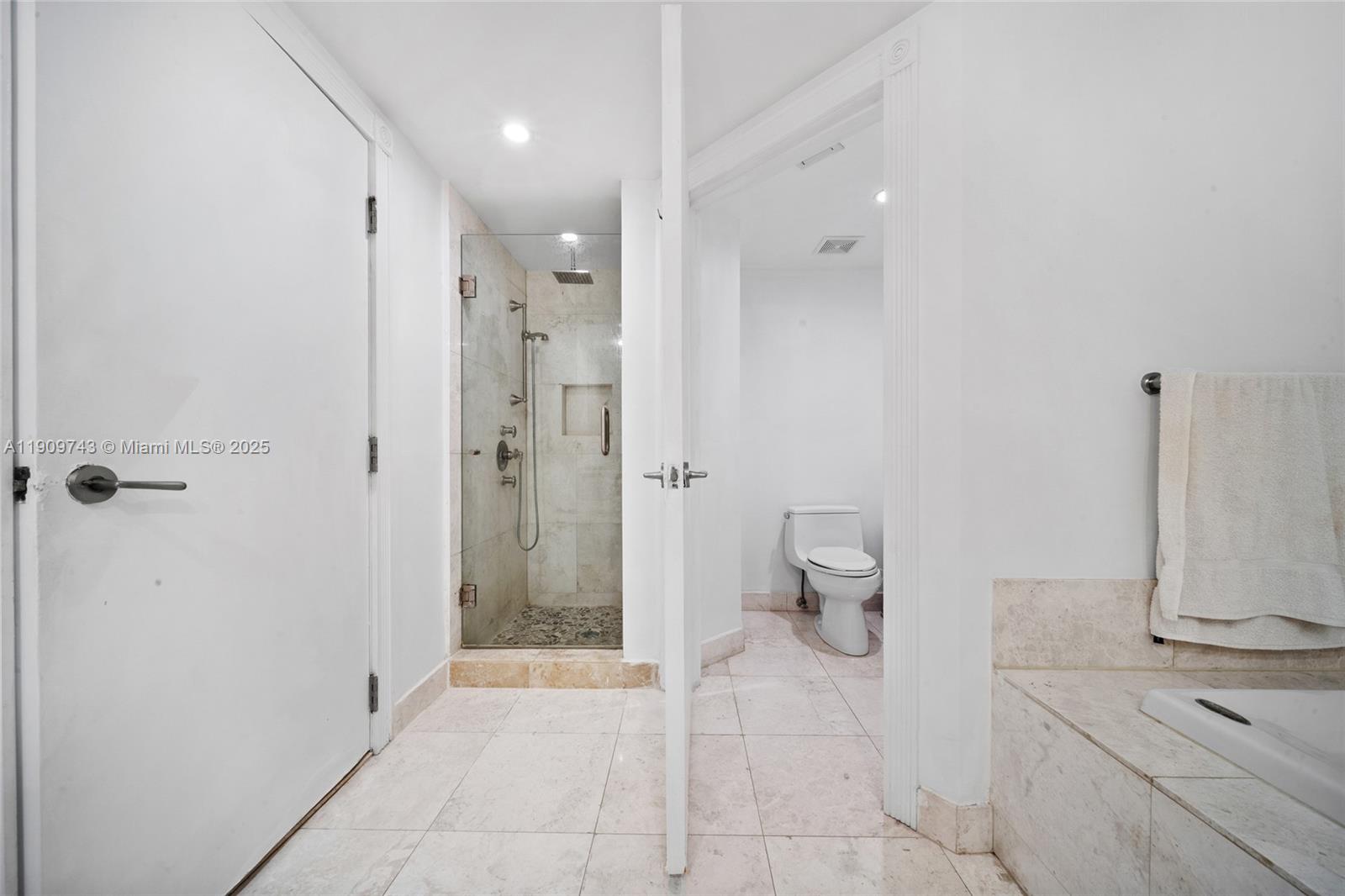 9401 Collins Avenue, Unit 205 Surfside, FL 33154 - Photo 22 of 36 a bathroom with a shower and a toilet