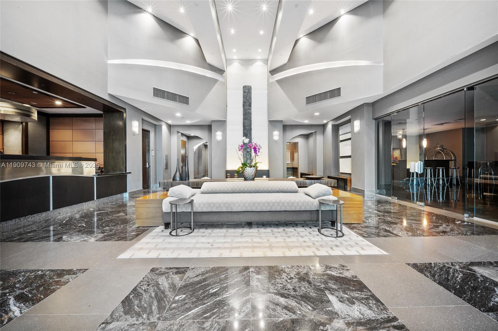 9401 Collins Avenue, Unit 205 Surfside, FL 33154 - Photo 28 of 36 a living room with a bed and glass table