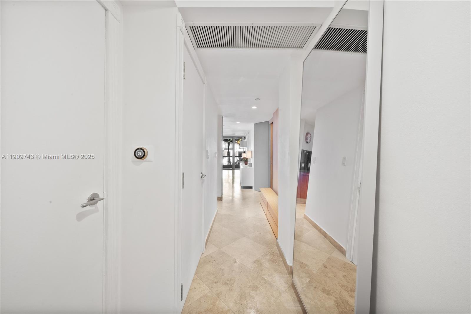 9401 Collins Avenue, Unit 205 Surfside, FL 33154 - Photo 8 of 36 a view of a hallway with wooden floor and a bathroom