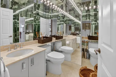 a bathroom with a sink a toilet and a large mirror
