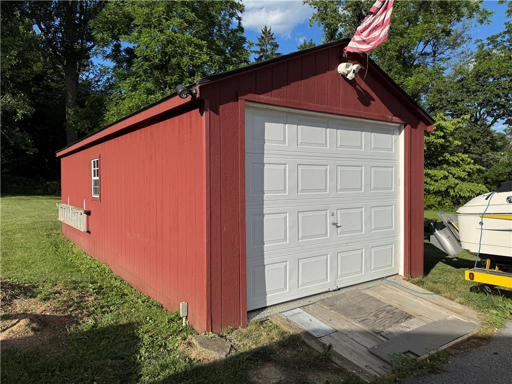 4425 Vera Cruz Road Center Valley, PA 18034 - Photo 4 of 4 A vibrant red shed offers convenient storage with a dedicated garage door and practical side access.