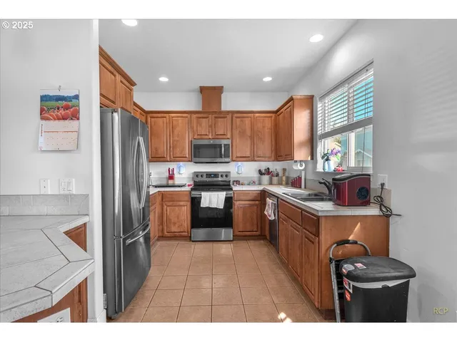 a kitchen with stainless steel appliances granite countertop a refrigerator stove top oven a sink and dishwasher