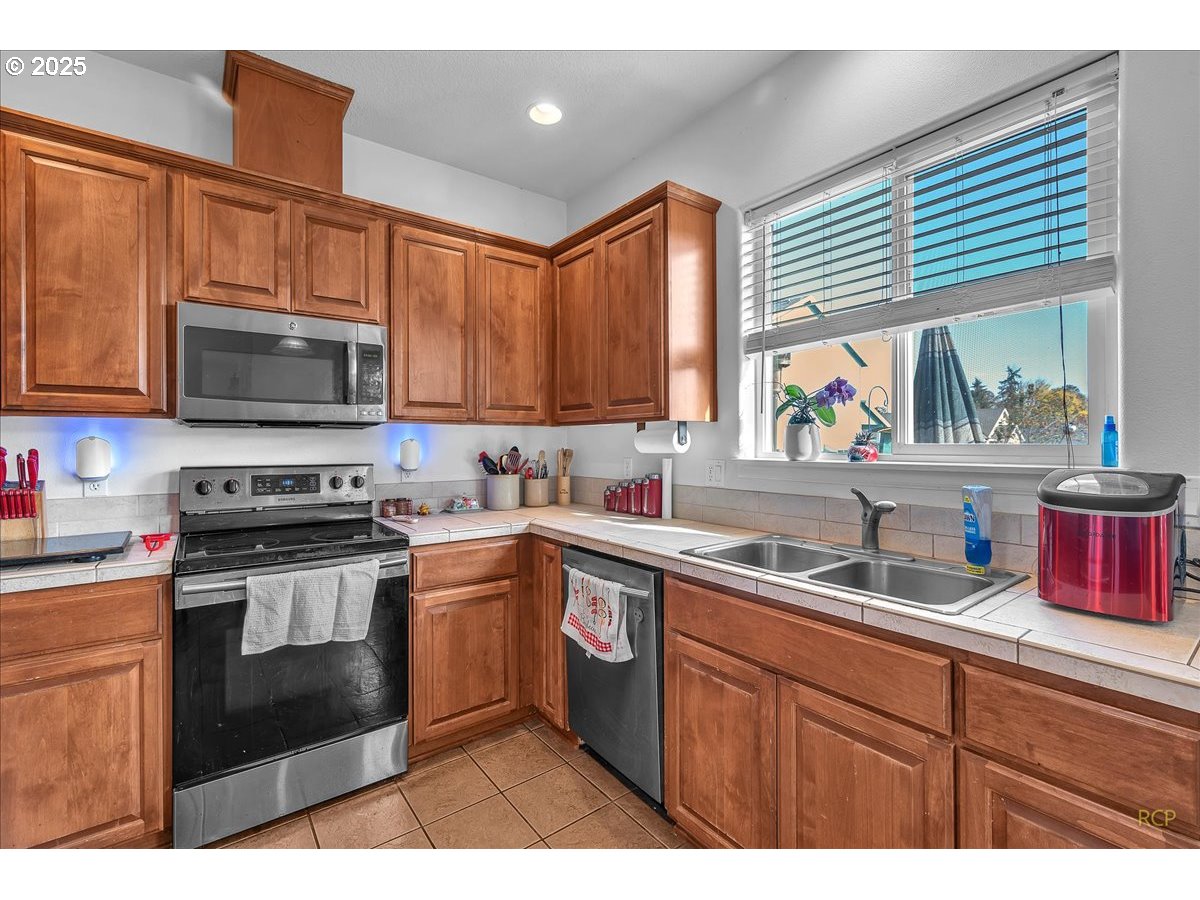 59174 Whitetail Avenue St. Helens, OR 97051 - Photo 13 of 34 a kitchen with stainless steel appliances a stove sink microwave and cabinets