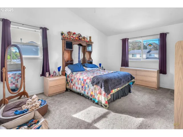 a bedroom with a bed and a large mirror on dresser