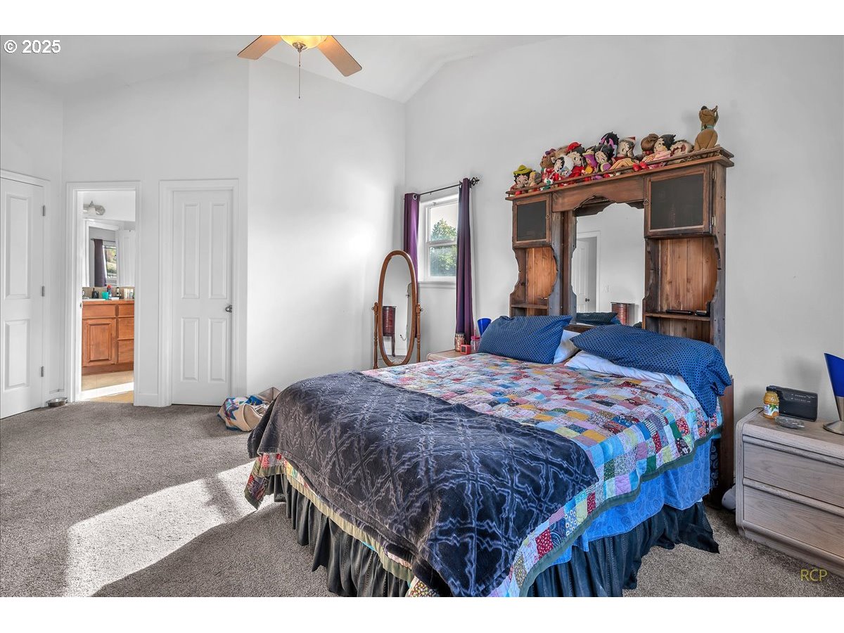 59174 Whitetail Avenue St. Helens, OR 97051 - Photo 23 of 34 a bedroom with a bed and a large mirror on dresser